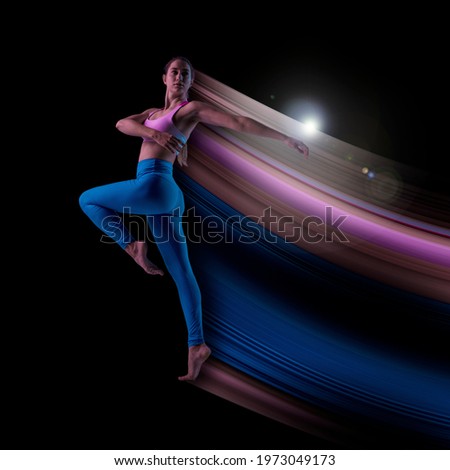 Young modern female athlete in neon light on black background. Concept of motion and action in sport. Training in jump, flight. Sport, healthy lifestyle, movement, advertising. Abstract design.