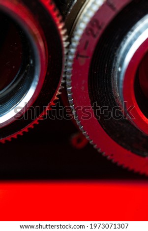 retro camera gears close-up on a red background.