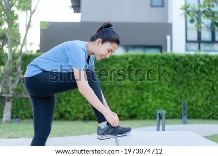 Asian women tying their shoes before going for a run at Sathorn Park