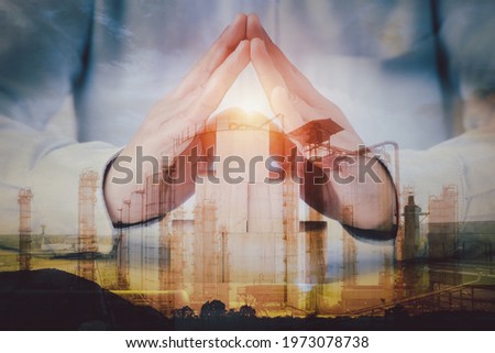Double exposure image concept, hand holding wooden block idea business industrial technology future plant and enegry graphic design. Oil, gas and petrochemical refinery factory with background.