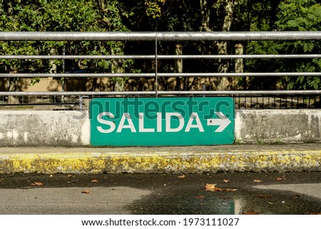 Green sign that says Exit in Spanish