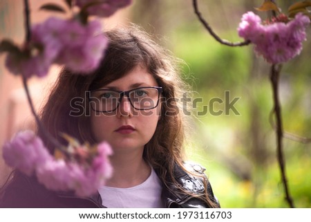 Portrait of a young beautiful Ukrainian woman near the sakura branch. Sakura. Soft background. 