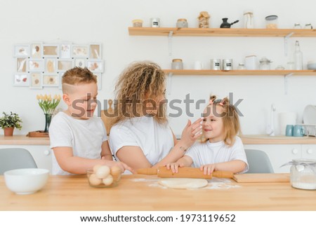 happy family in the kitchen. mother and children preparing the dough, bake cookies