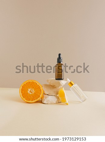 Real unique still life composition. Dropper bottle and citrus fruit on earthy colored background. Beauty and health concept. Minimal aesthetic. Royalty-Free Stock Photo #1973129153