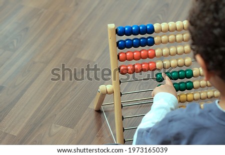boy going back to school with educational abacus sitting on the floor playing school stock photo