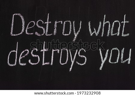 Chalkboard text Destroy what destroys you. Motivational lettering Royalty-Free Stock Photo #1973232908