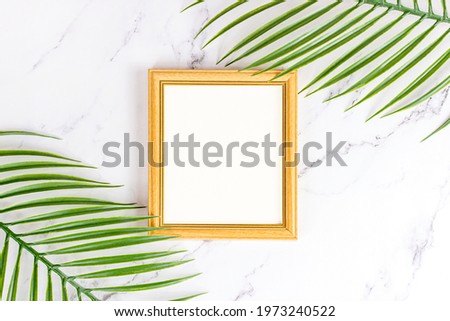 Top view of retro wooden empty photo frame with natural decorations, branches and leaves on light background as a mock up and blank template for cards, posters and paintings design