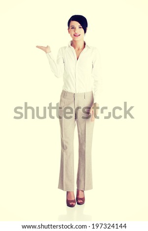 Happy young business woman showing copy space.