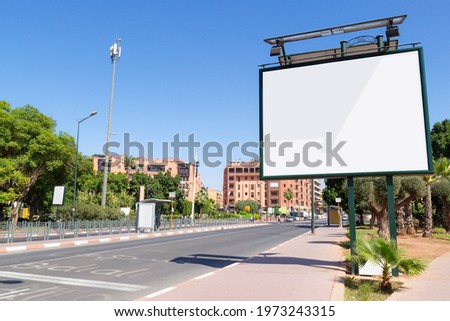 Empty mockup of blank white billboard on street in Marrakesh, Morocco. Outdoor billboard or advertising poster with copy space. Pavement inscription in French and Arabic. Translation: Sidi Ali.