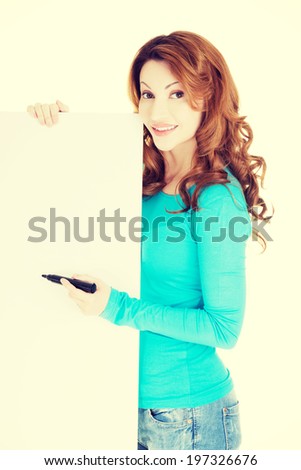 Happy beautiful woman writing with a marker on blank board. Student, teacher or businesswoman.