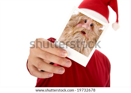 man in red shirt and santa hat holding a photo in front of his face