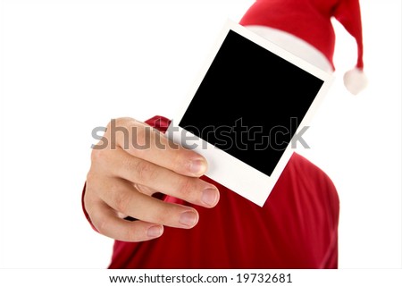 man in red shirt and santa hat holding a photo in front of his face
