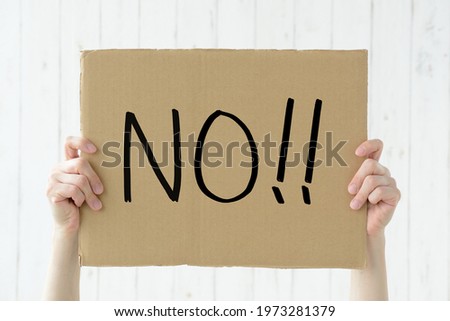 Human's hands holding up cardboard with NO word
