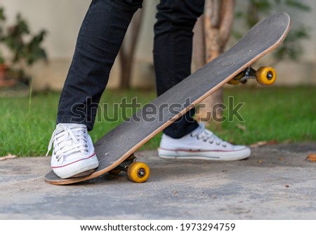 A teenager wearing white shoes playing a skateboard