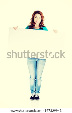 Portrait of happy woman with blank board