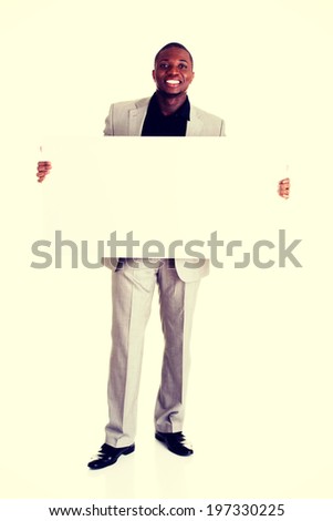 Happy successful businessman holding and showing blank advertisement.