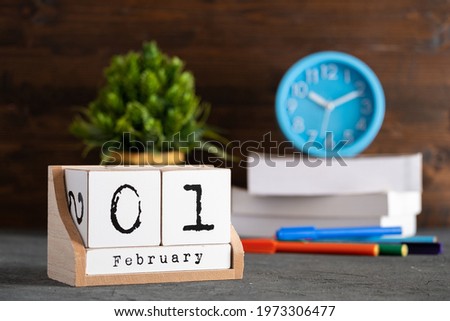 February 01st. February 01 wooden cube calendar with blur objects on background.