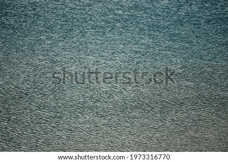 Texture of dark green calm water of lake. Meditative ripples on water surface. Nature minimal background of deep green lake. Natural backdrop of clear dark turquoise water. Full frame of lake fragment