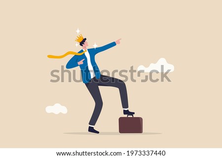 Success businessman king proud of his achievement, work happiness or self esteem, freedom or entrepreneurship concept, cheerful businessman wearing king crown step on briefcase pointing to the sky. Royalty-Free Stock Photo #1973337440