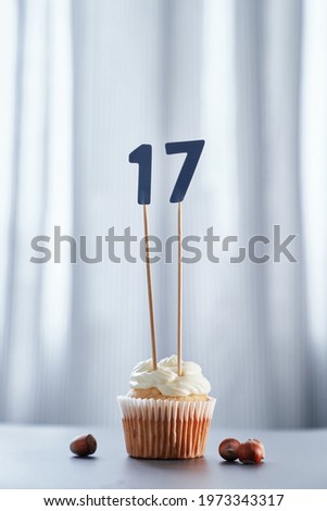 Homemade birthday cupcake with creamy topping and number 17 seventeen. Minimalistic birthday or anniversary cake concept. High quality vertical image