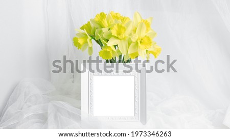 mockup of spring postcard, invitation, banner. yellow daffodils and white photo frame with place for text. minimalistic holiday layout, copy space.