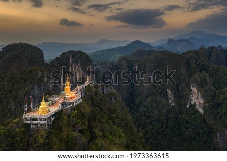 Aerial view from drone of "Wat Tham Suea" (The Tiger Cave temple) during sunset well-known temple on a hilltop in Krabi, Thailand. Royalty-Free Stock Photo #1973363615