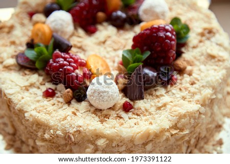 Birthday cake decorated with fruit, pomegranate seeds, chocolate and grapes. Top view. High quality photo