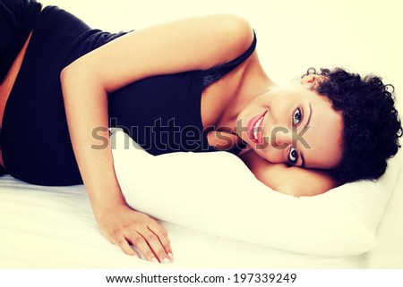 Pregnant woman sleeping on her bed
