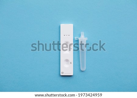 Coronavirus lateral flow home testing kit against a blue background Royalty-Free Stock Photo #1973424959