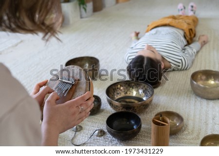 Tibet singing bowls massage and sound therapy concept. Closeup of healer using traditional nepal music instrument for meditative practice from buddhism culture. Stress management and balance concept Royalty-Free Stock Photo #1973431229