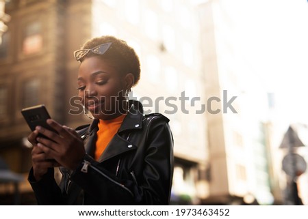  Young african woman using the phone. Beautiful woman typing a message.