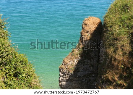 blue and green water and brown cliffs