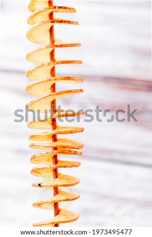Homemade potato chips on stick on wooden background. Photo for the menu and site