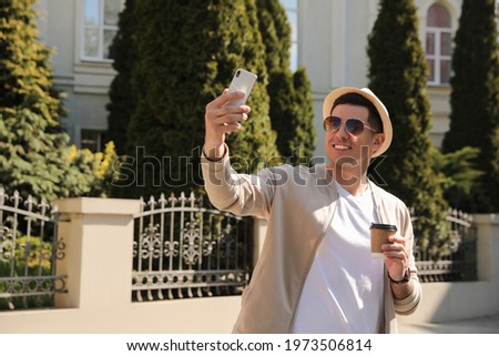 Happy man taking selfie on city street