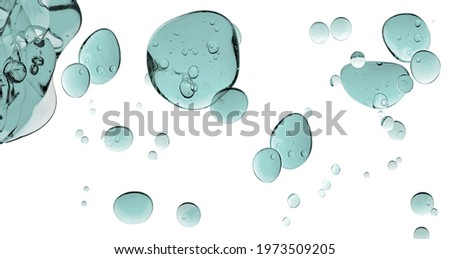 Liquid gel cosmetic texture. Greenish-blue gel drops. Close up of transparent cosmetic product isolated on white background.