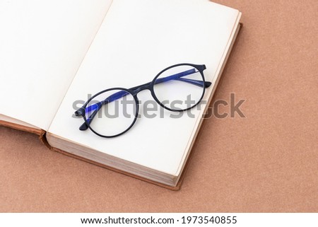 Old books with eye-glasses isolated on craft background.