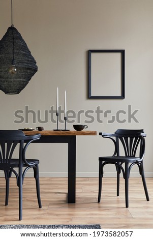 Rustic interior design of dining room with wooden family table, candelstick, retro chair, cup of coffee, decoration, mock up picture frame and elegant personal accessories. Beige wall. Template.