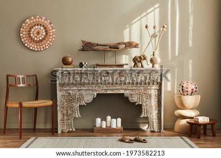 Modern concept of mediterranean interior with design furniture, chair, ethnic shlef, art paintings, decoration, carpet and personal accessories in stylish home decor. Template. Royalty-Free Stock Photo #1973582213