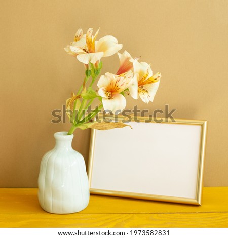 Empty photo frame with flowers on wooden table. brown background
