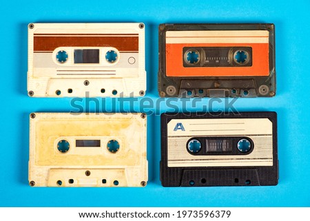 Four Old Audio Cassettes on the Blue Paper Background closeup