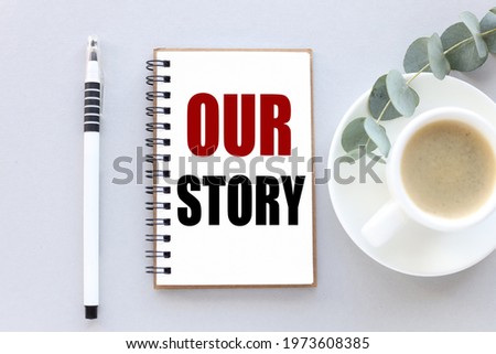 our story. text on white notepad paper. near cups with coffee and plants on a gray background.