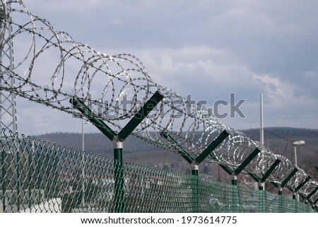 The main subject is out of focus, Barbed wire fence outside closeup blue sky felony prison freedom stop trespassing security 