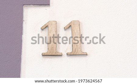 Silver number eleven on white wall