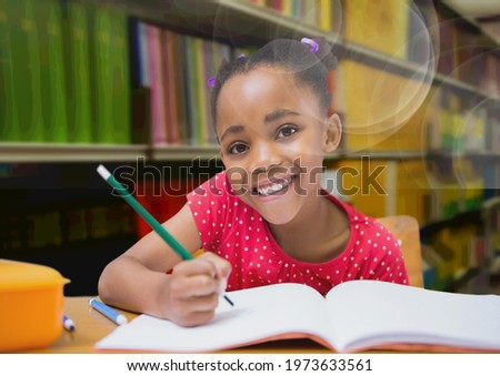 Composition of smiling african american schoolgirl in library with spots in background. back to school, education and learning concept digitally generated image.