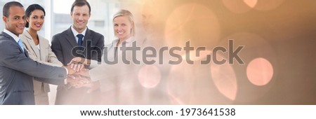 Composition of smiling business people stacking hands with spots of light. business, motivation and teamwork concept digitally generated image.