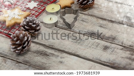 Composition of christmas decorations with copy space on wooden surface. technology and christmas tradition concept digitally generated image.