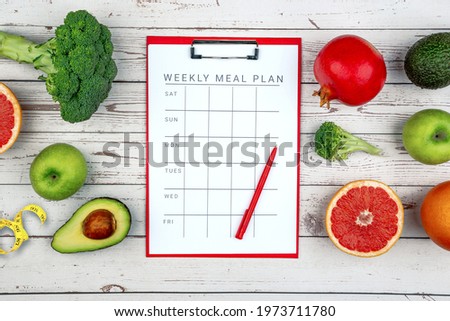 Healthy lifestyle workout concept with training equipment. The idea of how to achieve harmony and longevity while Slimming. Weekly meal plan tab Royalty-Free Stock Photo #1973711780