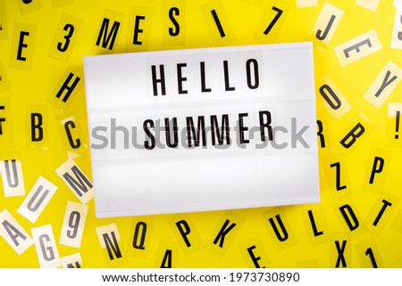 Lightbox with text HELLO SUMMER on yellow background with black letters randomly scattered. Concept of summertime, hot travel season, vacation, holiday, event ad, offer, sale, discount, promotion