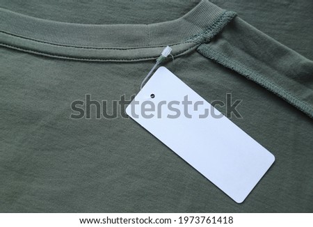 Blank space on price tag of green T- shirt for adding text and price in selling production