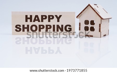 Economy and business concept. There is a wooden house and a sign on the table - happy shopping
